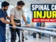 Patient practising supported standing with a physiotherapist during spinal cord injury rehabilitation.
